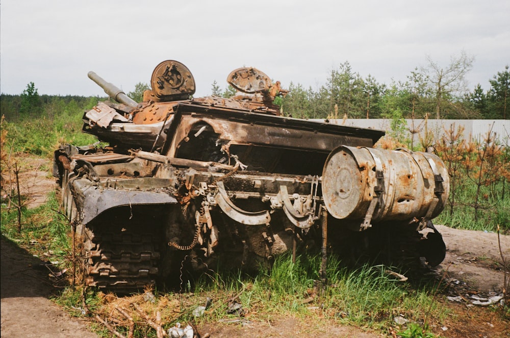 an old rusted out tank sitting in a field
