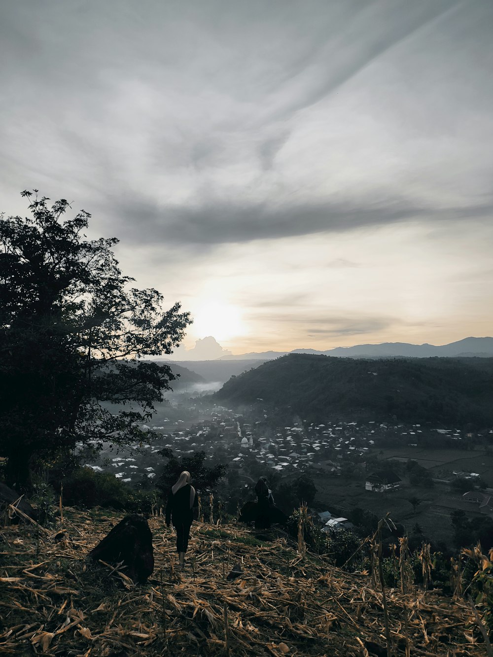 a man standing on top of a grass covered hillside