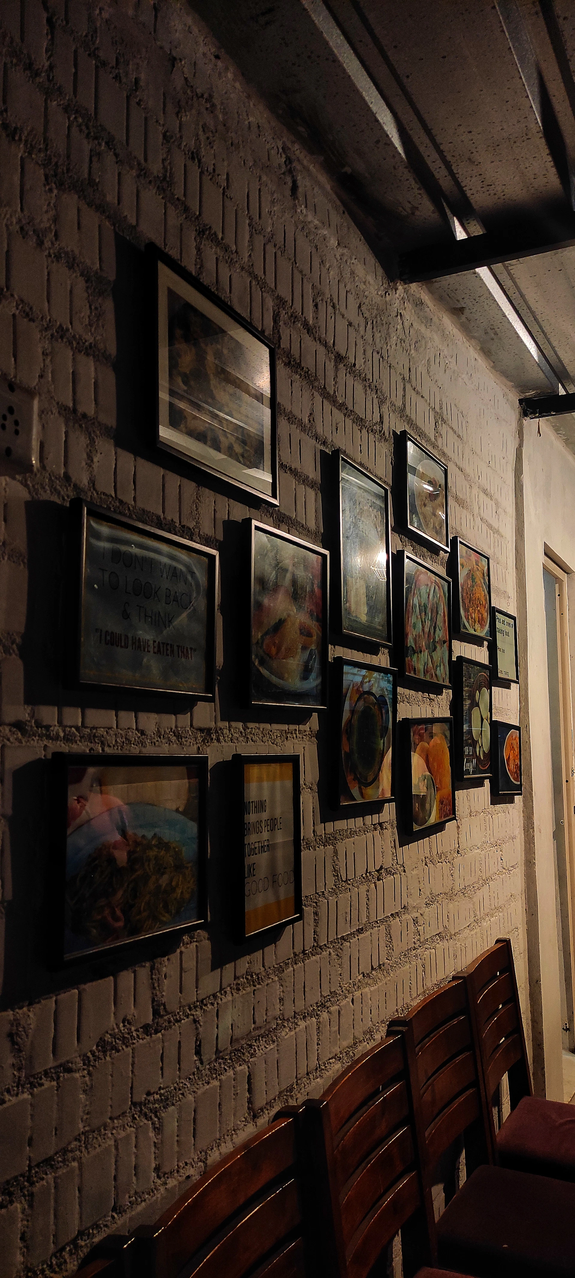 The cozy interior of Mat's Kebab with black and white tiled walls, Dutch orange accents, and graffiti-style fonts glowing under soft lighting.