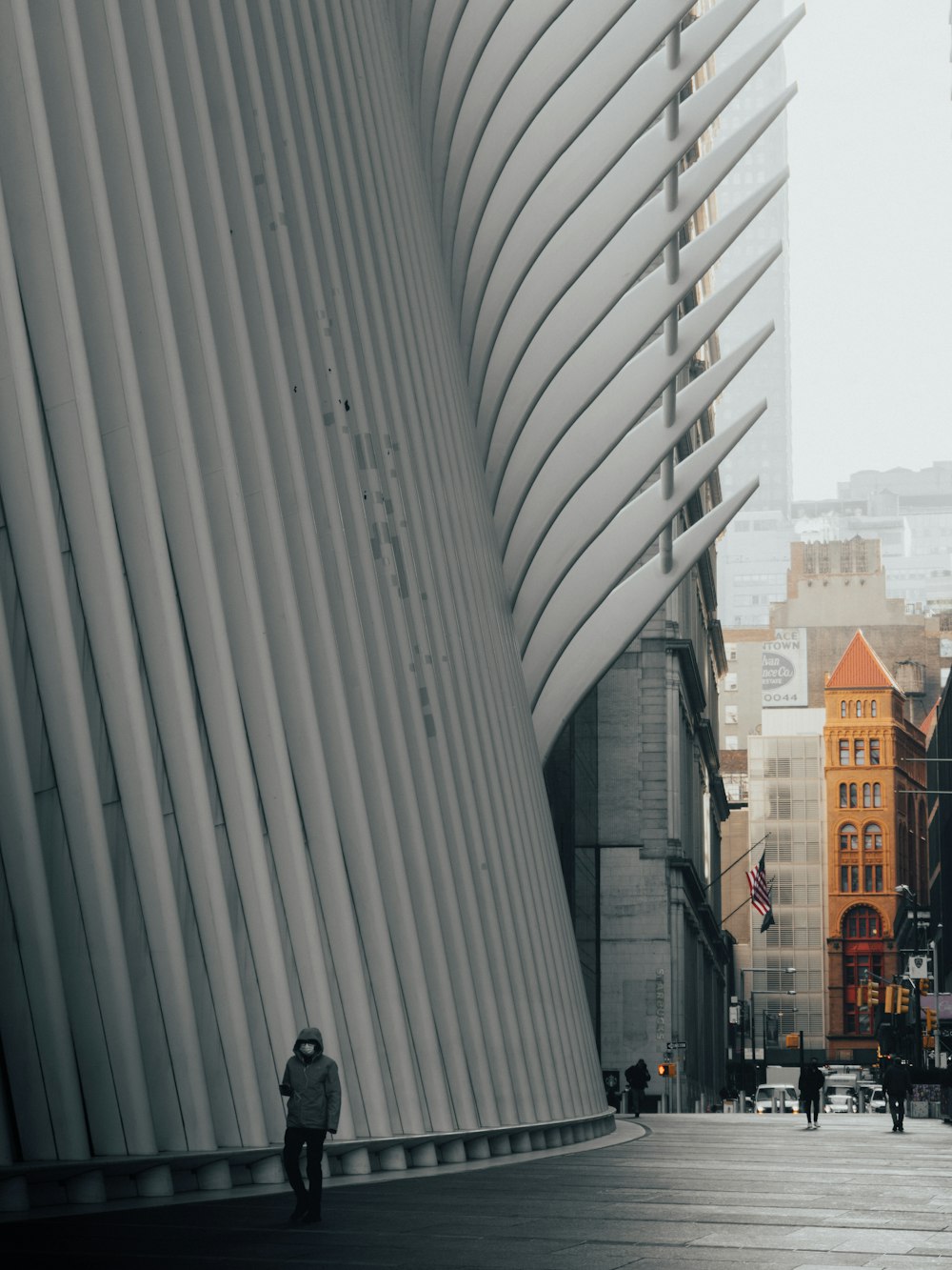 a man walking down a street next to tall buildings