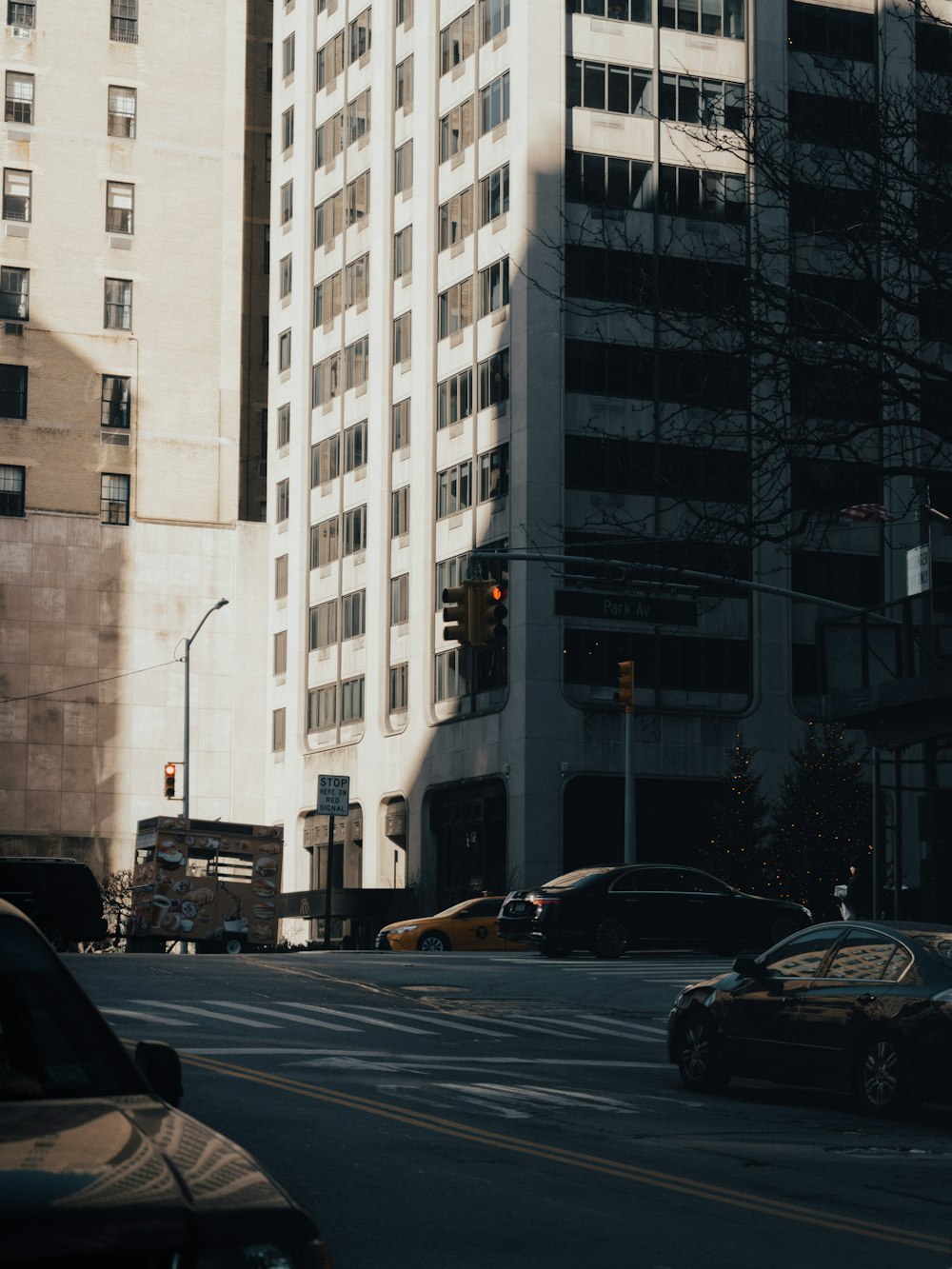 a city street filled with lots of traffic next to tall buildings