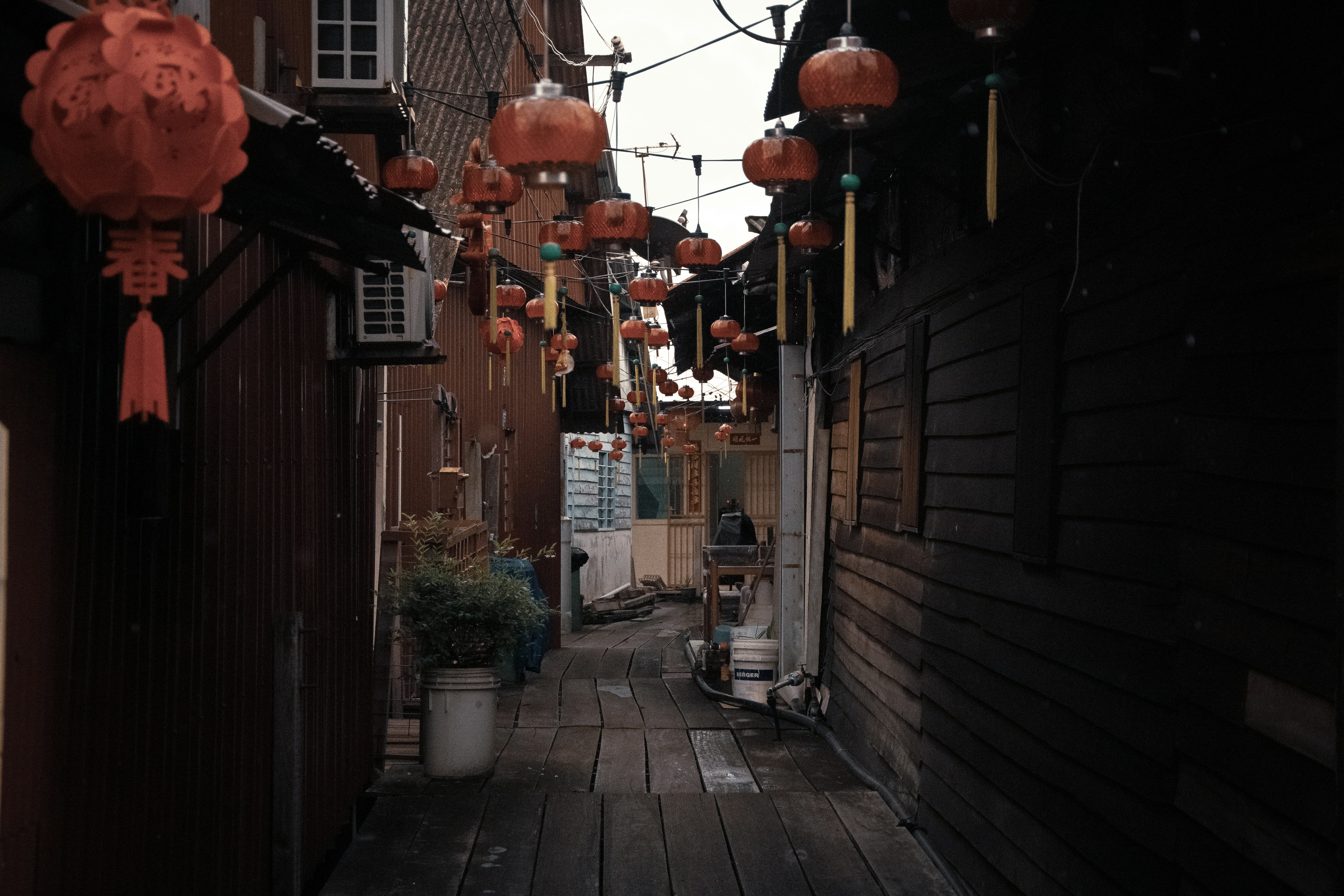 A narrow alley with lanterns hanging from the ceiling photo – Free ...
