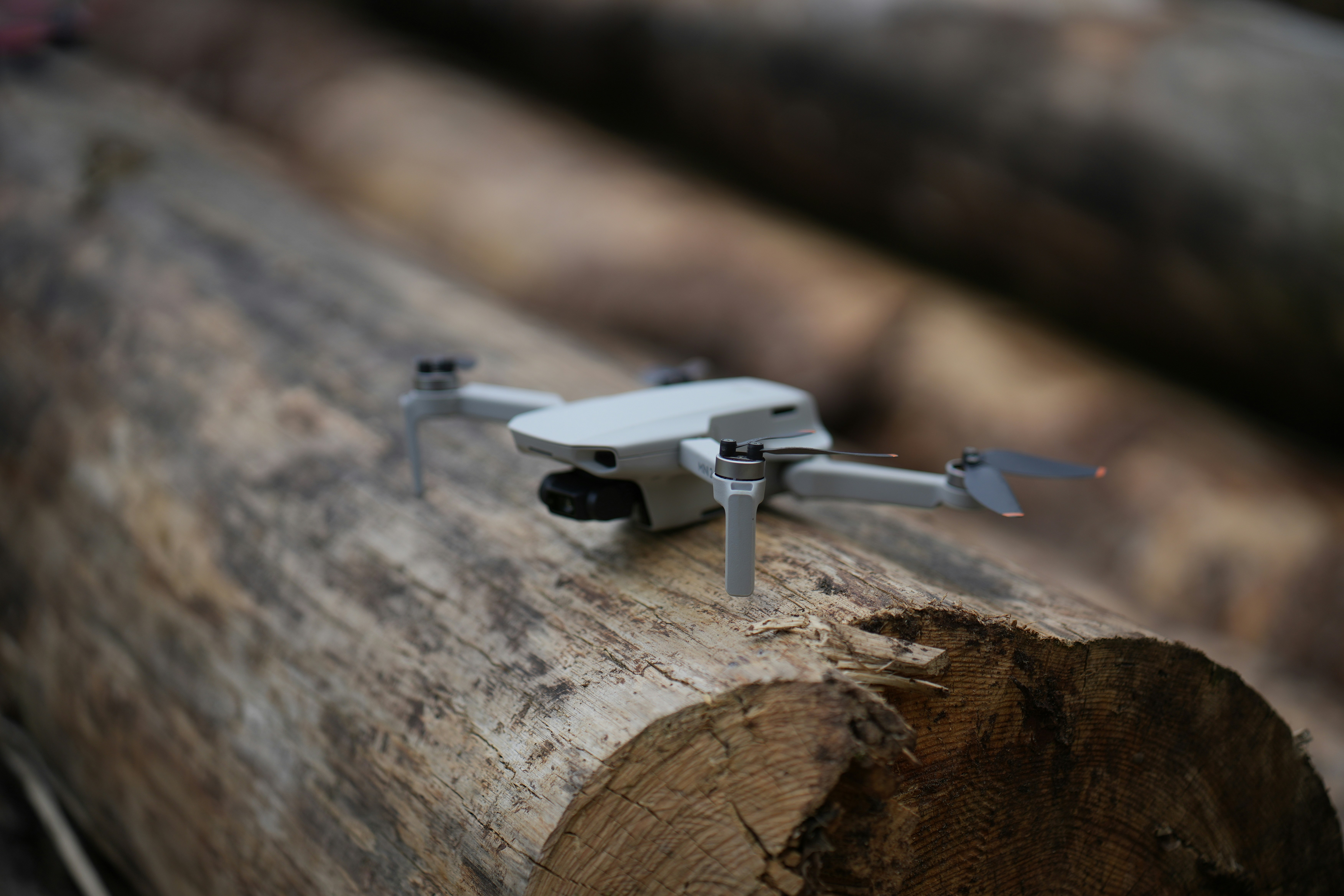 una piccola macchina fotografica bianca seduta sopra un pezzo di legno