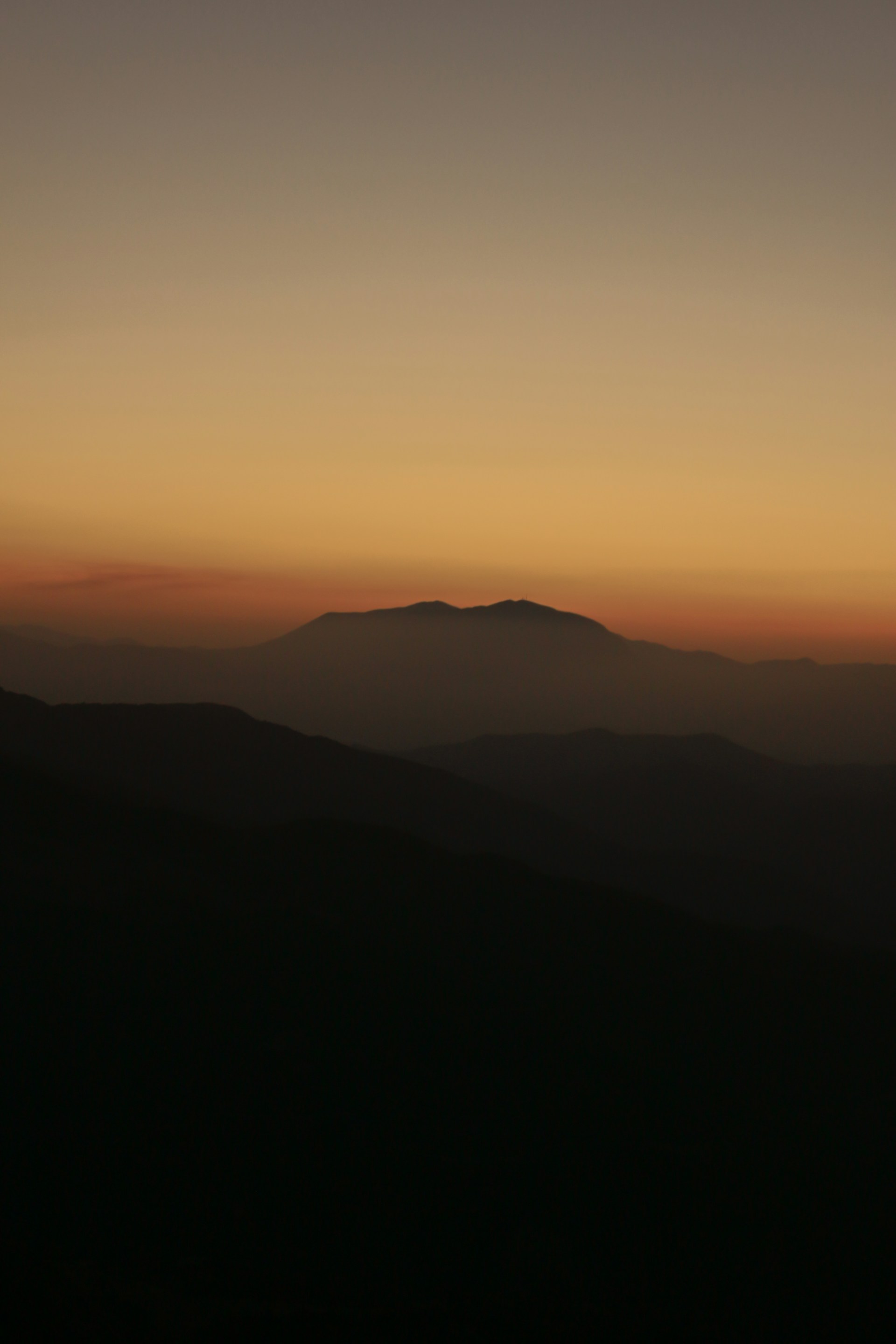 the sun is setting over a mountain range