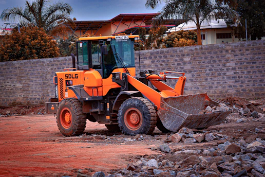 a large orange bulldozer sitting on top of a dirt field