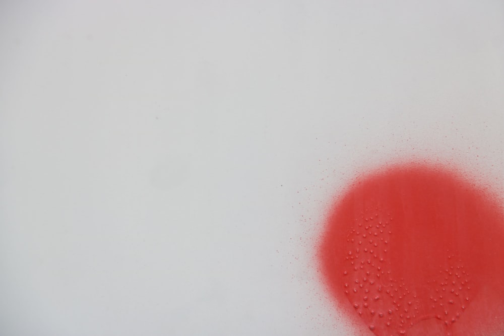 a red circle on a white background with water droplets