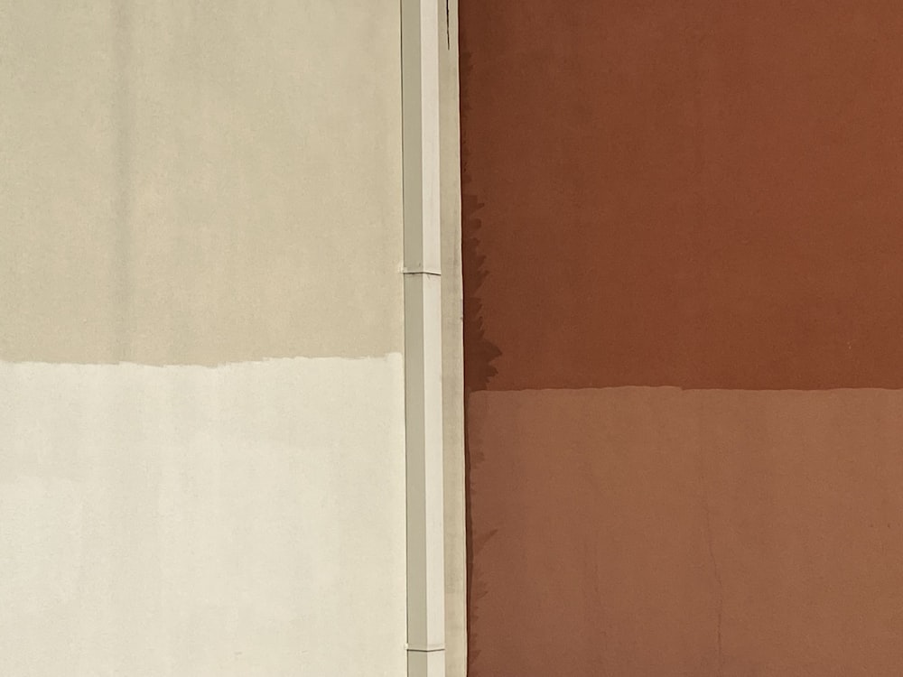 a red fire hydrant in front of a brown and white wall