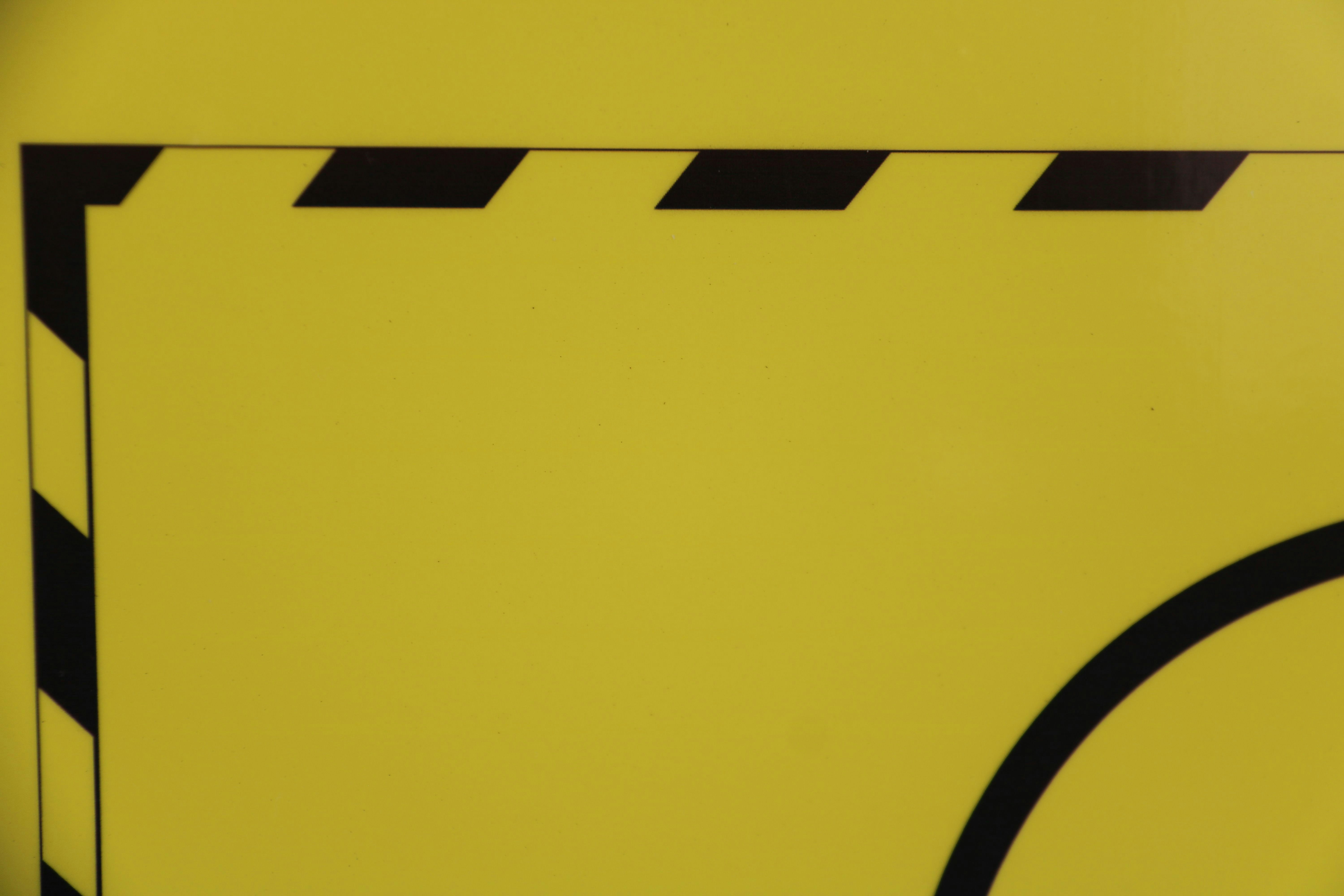 Gros plan d’un panneau jaune avec des rayures noires