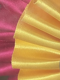 Close-up of a handmade pink bow with delicate stitching on soft fabric.