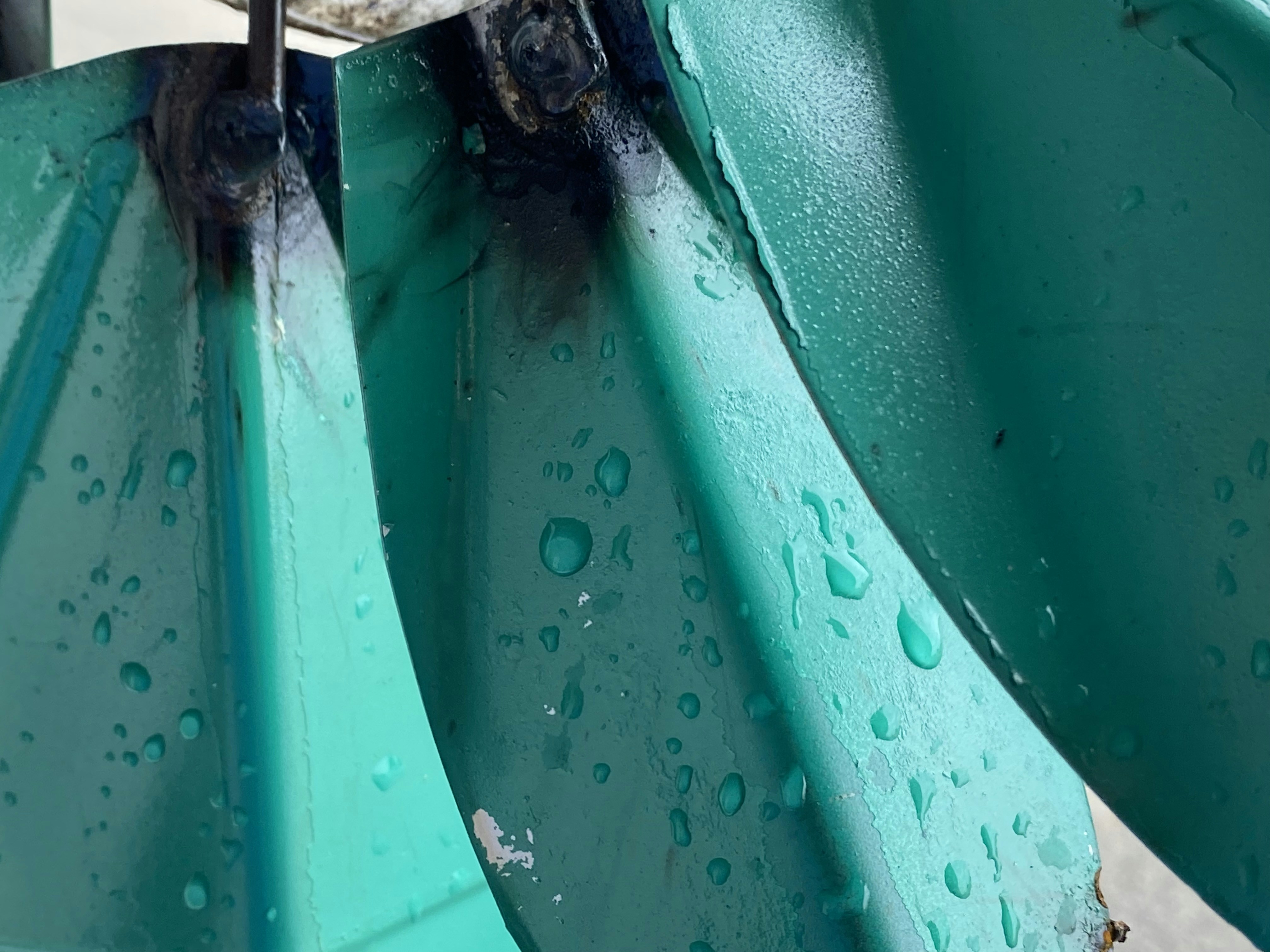 un gros plan d’un objet métallique avec des gouttes d’eau dessus