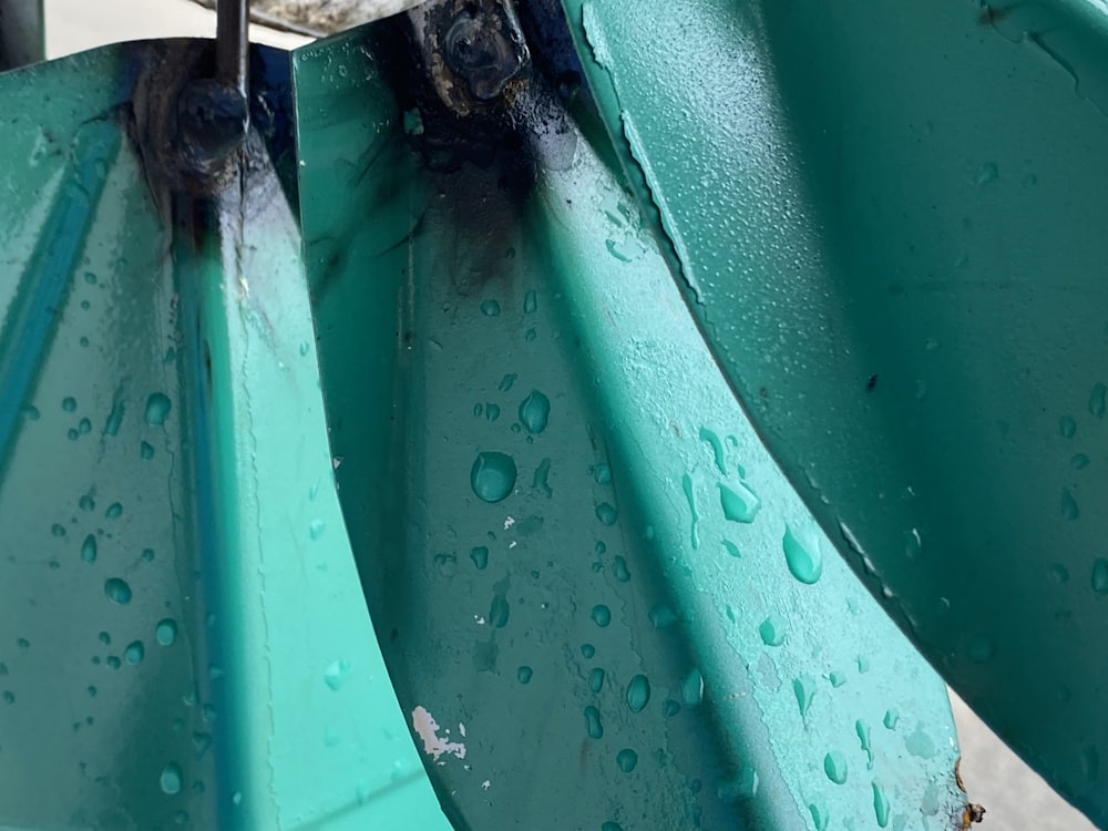 a close up of a metal object with water drops on it