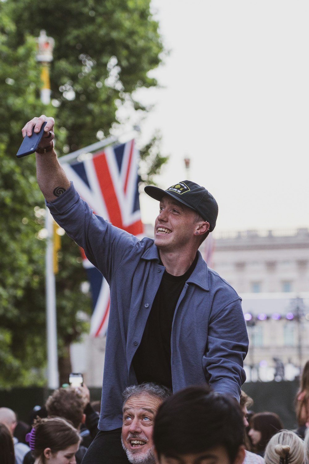 a man holding up a cell phone in front of a crowd of people