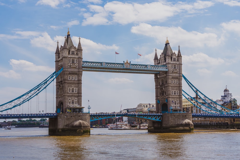 Un puente alto que se extiende sobre un río junto a un edificio alto