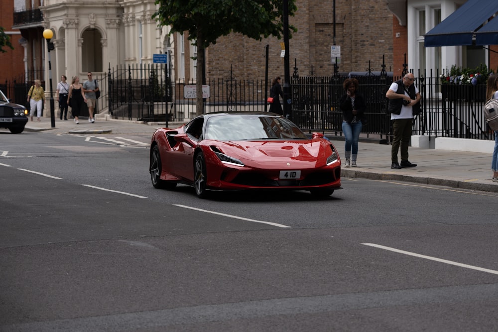 a red sports car driving down a street