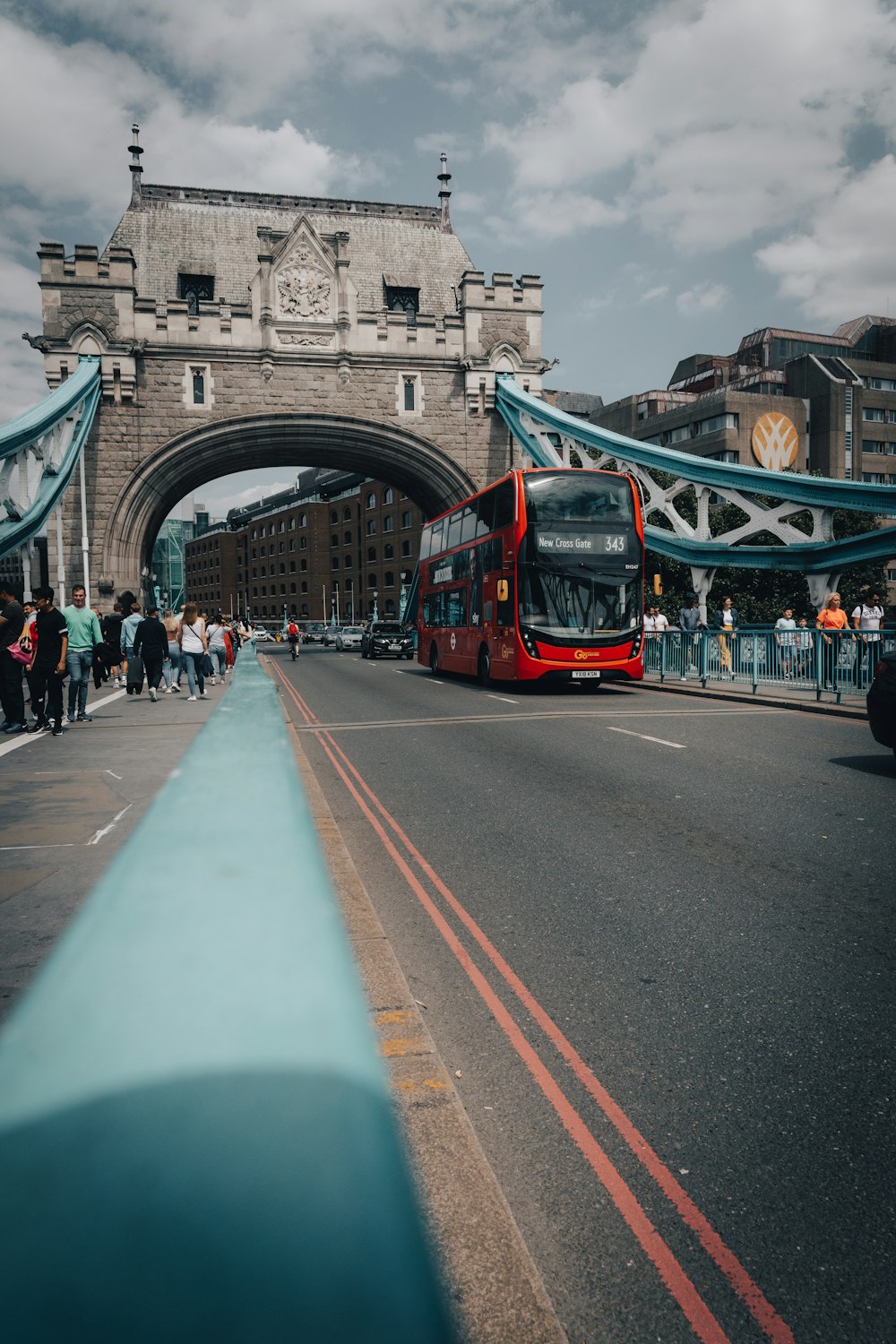 Ein roter Doppeldeckerbus fährt unter einer Brücke hindurch