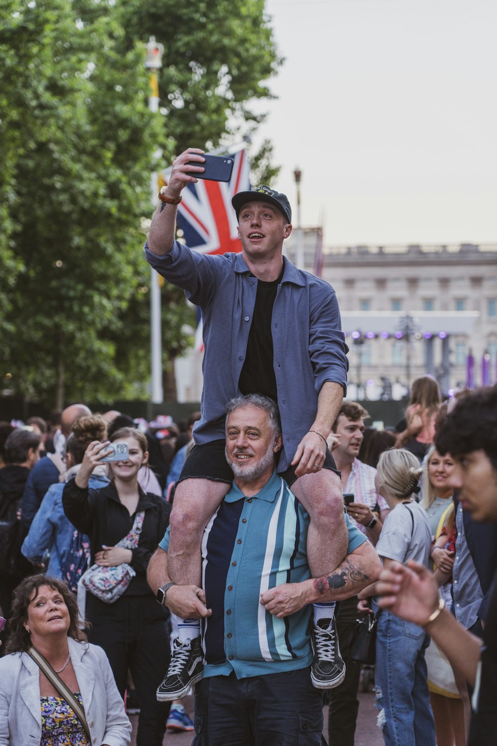 a man is sitting on top of another man's shoulders