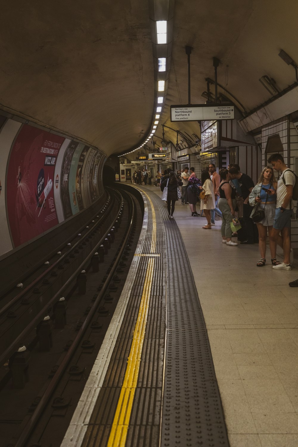 a group of people waiting for a train at a train station