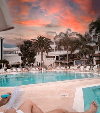 a person is reading a book near a swimming pool