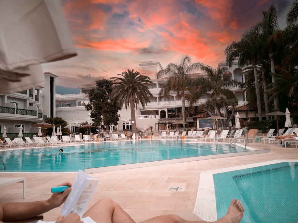 a person is reading a book near a swimming pool