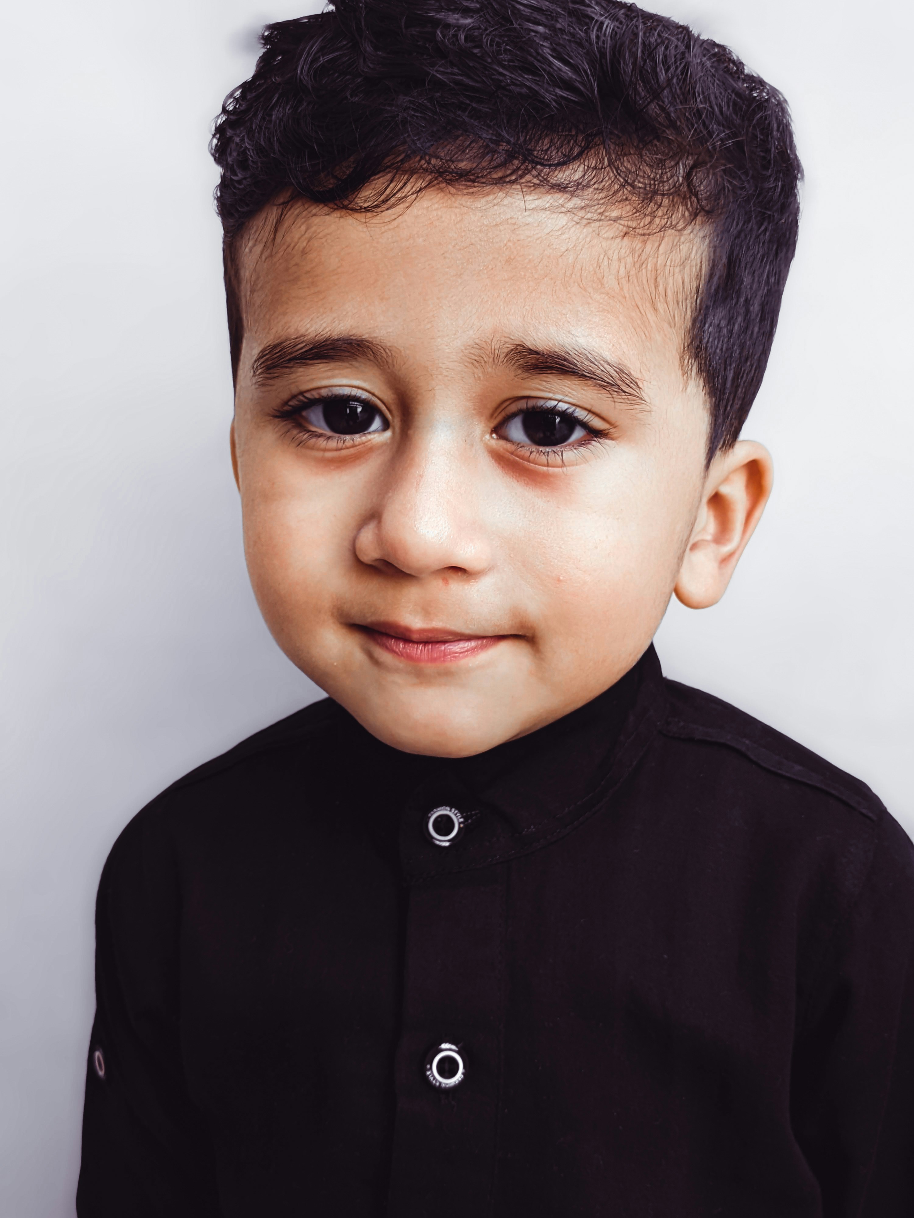 seorang anak laki-laki dengan kemeja hitam dan rambut hitam
