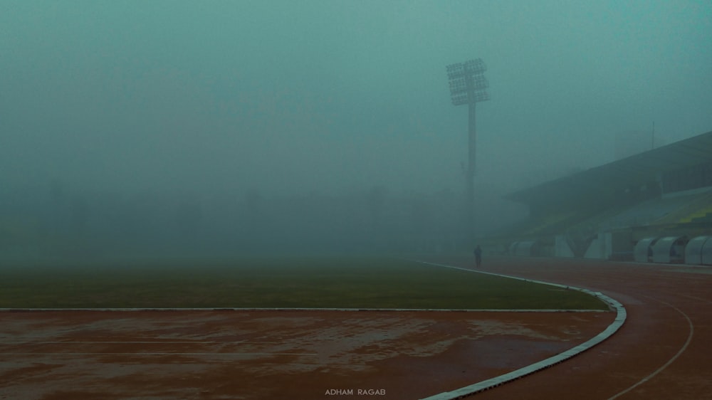 a foggy day at a baseball stadium with a baseball field