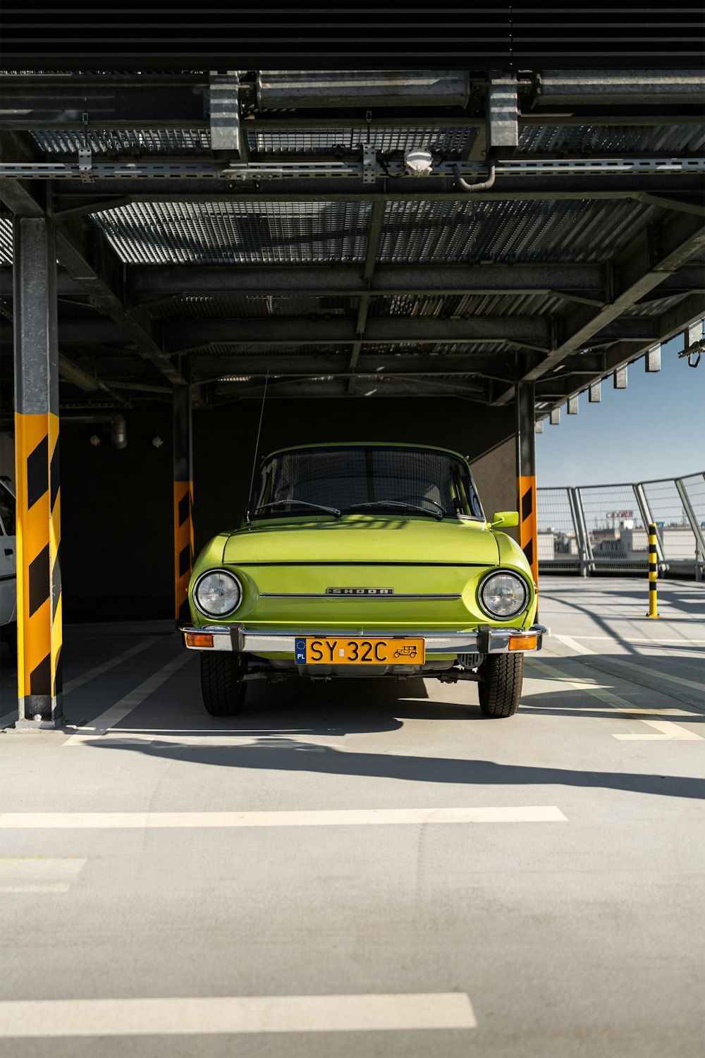 a green car parked in a parking garage