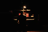 A serene musician lost in the flow of creating music in a cozy, candle-lit room.