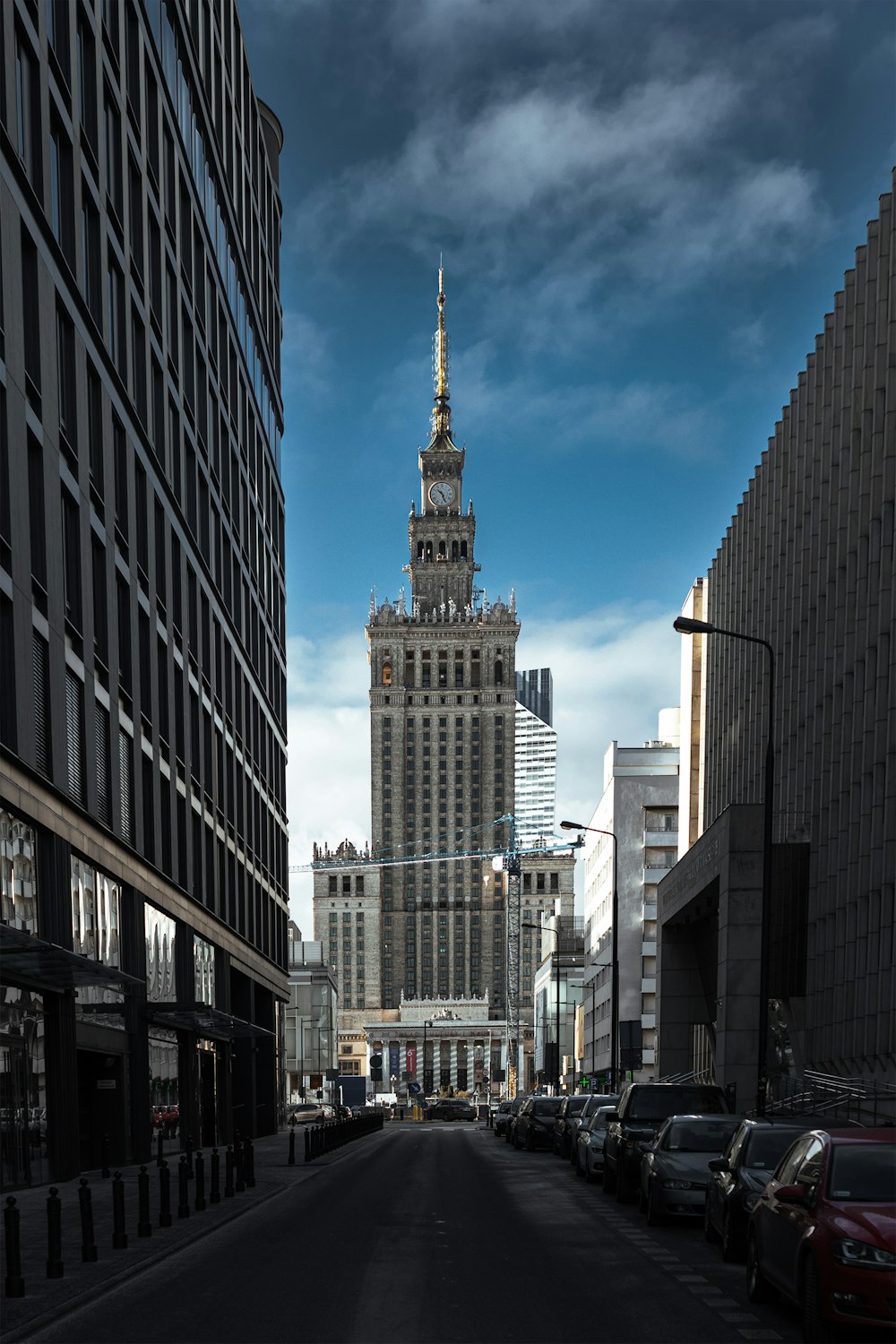 a city street lined with tall buildings under a cloudy sky