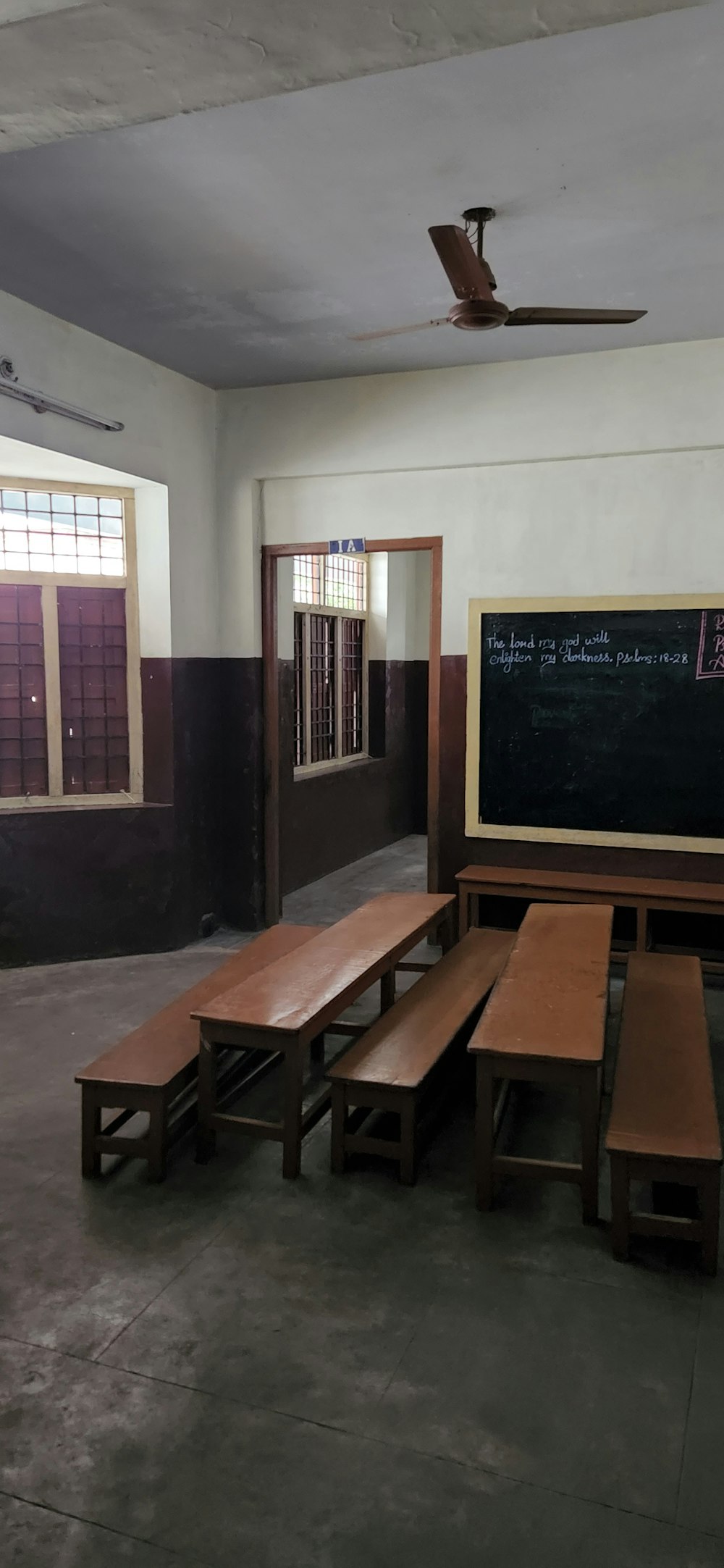 a classroom with a blackboard and wooden benches