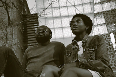 Two friends sitting apart, showing tension and misunderstanding in their body language.