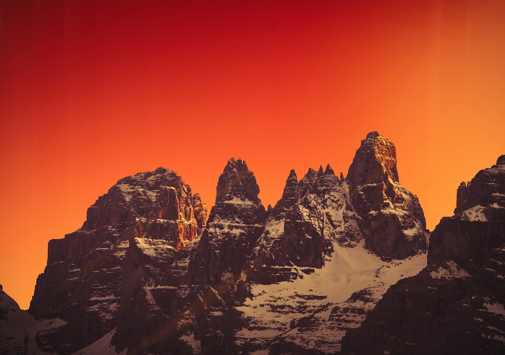 a mountain range with a red sky in the background