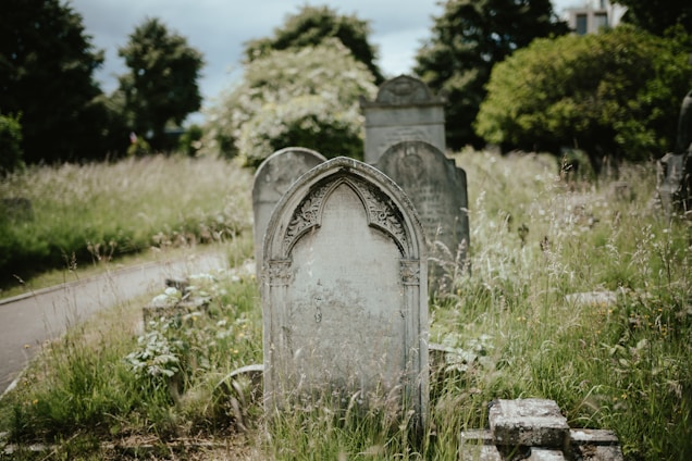 A peaceful Thomasville graveyard at sunset with old oak trees and weathered headstones.