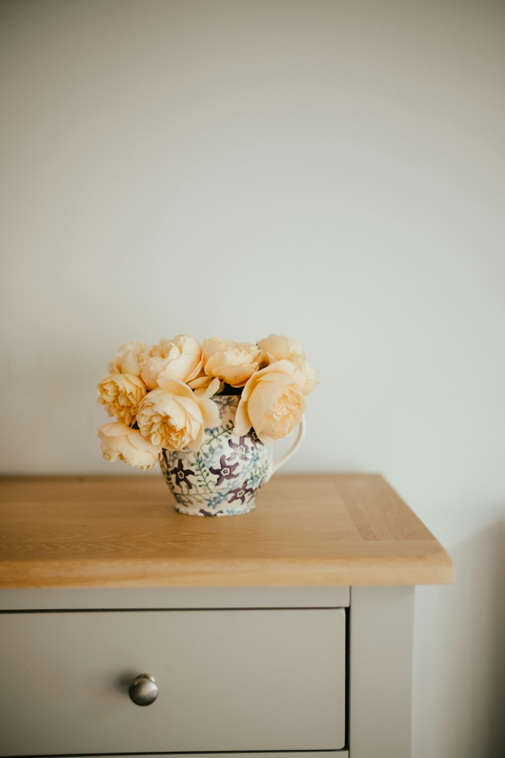 a vase filled with flowers sitting on top of a wooden table