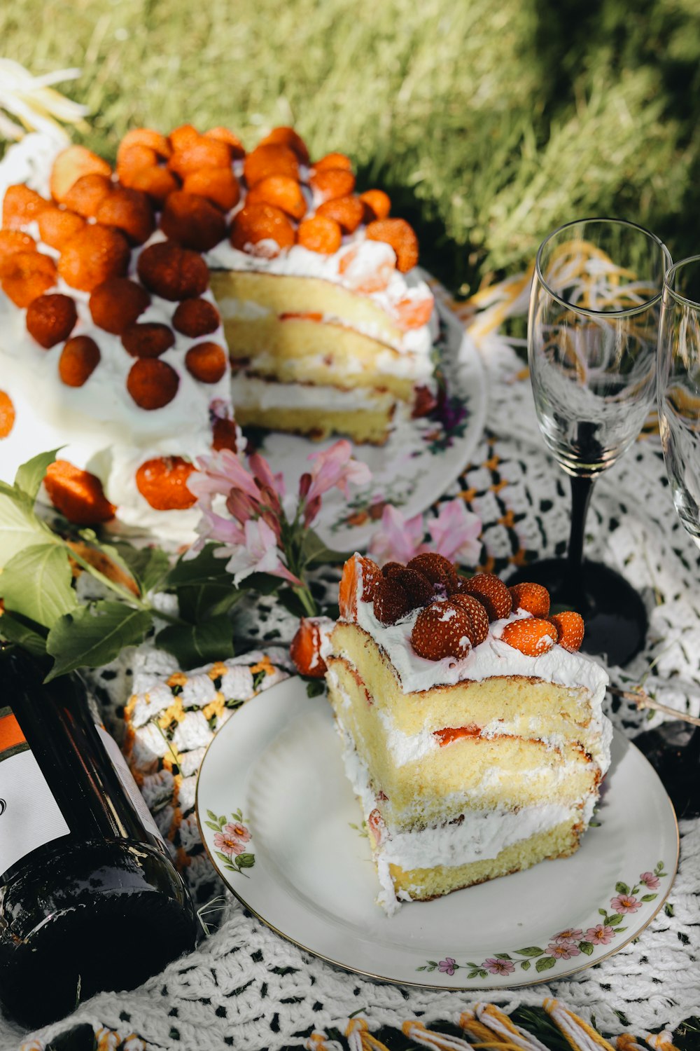 a piece of cake on a plate next to a bottle of wine