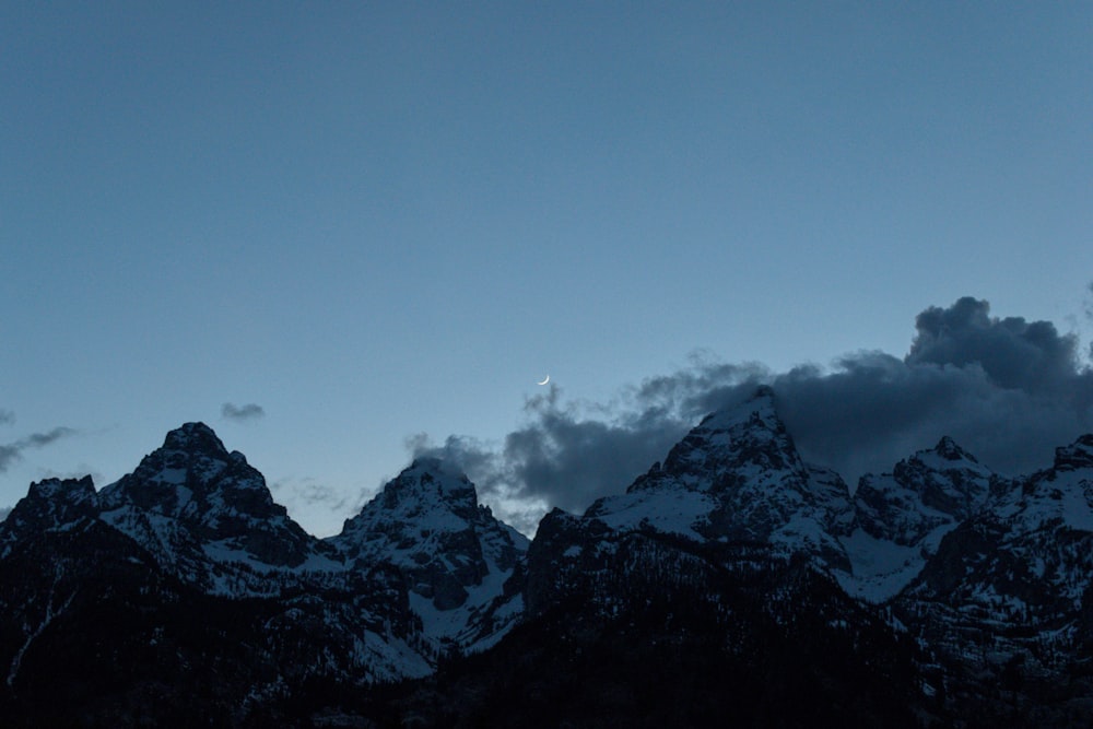 a group of mountains with clouds in the sky