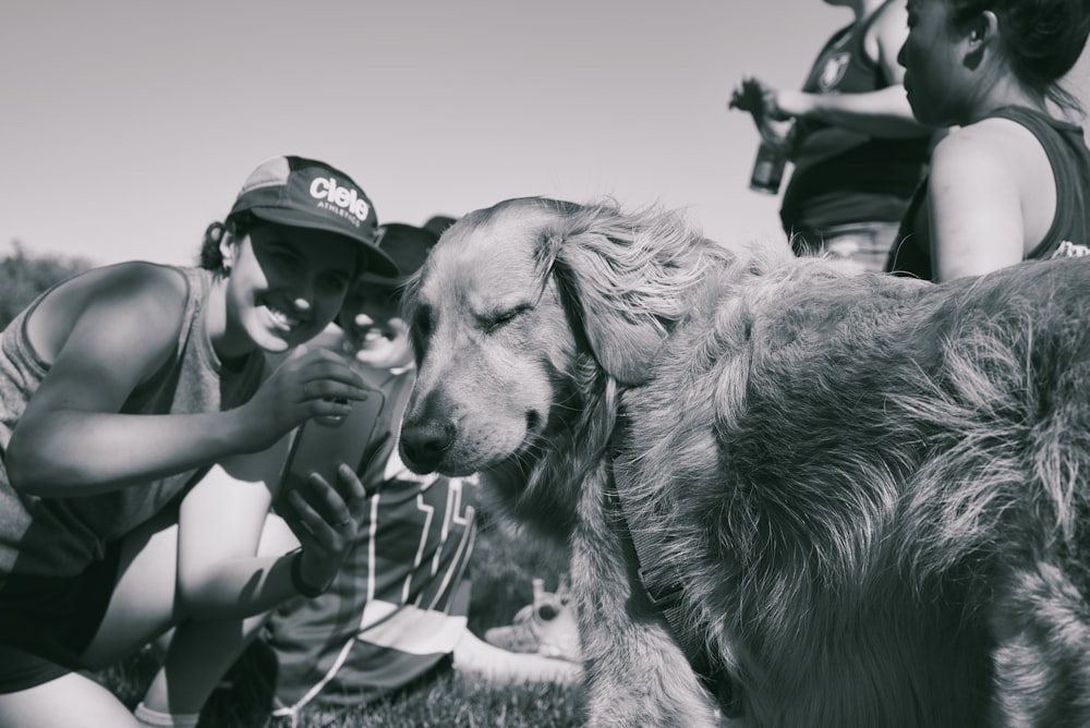 a woman kneeling down next to a dog