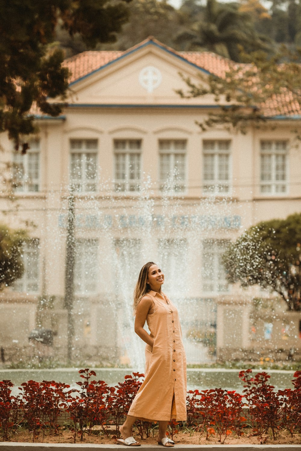 a woman standing in front of a fountain