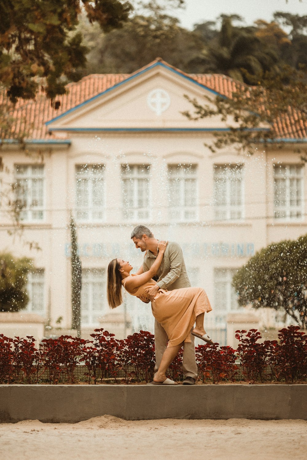 a man and a woman kissing in front of a building