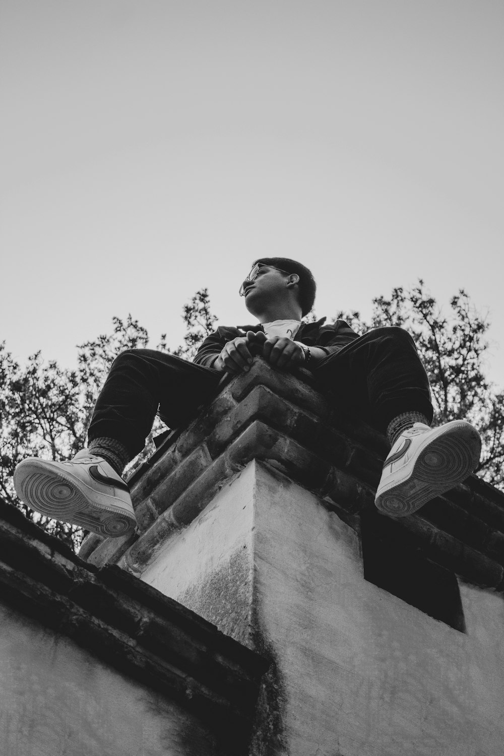 a man sitting on top of a brick building