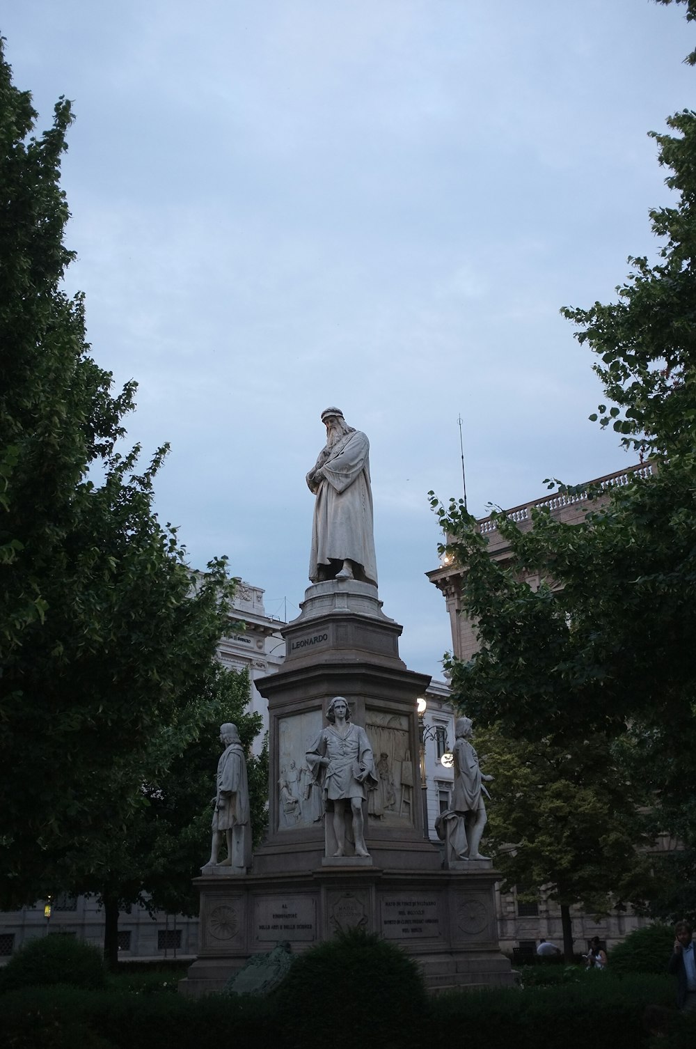 uma estátua de um homem em pé na frente de um edifício
