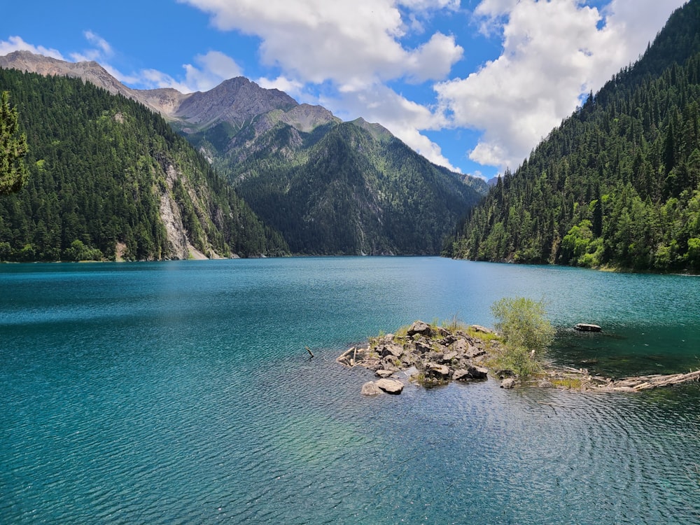 a small island in the middle of a lake surrounded by mountains