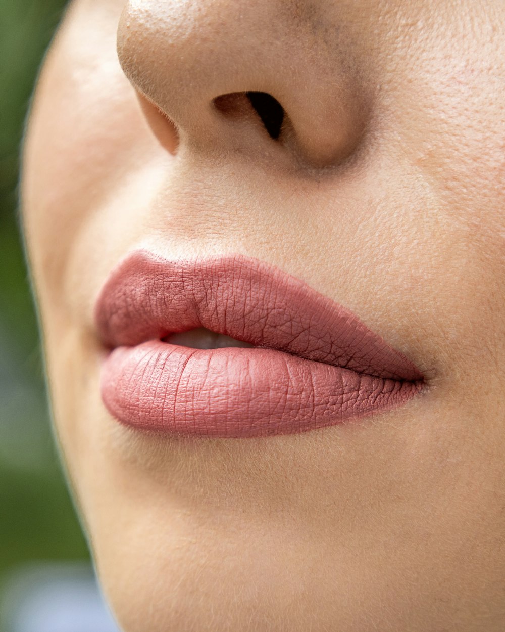 a close up of a woman's lips with a green background