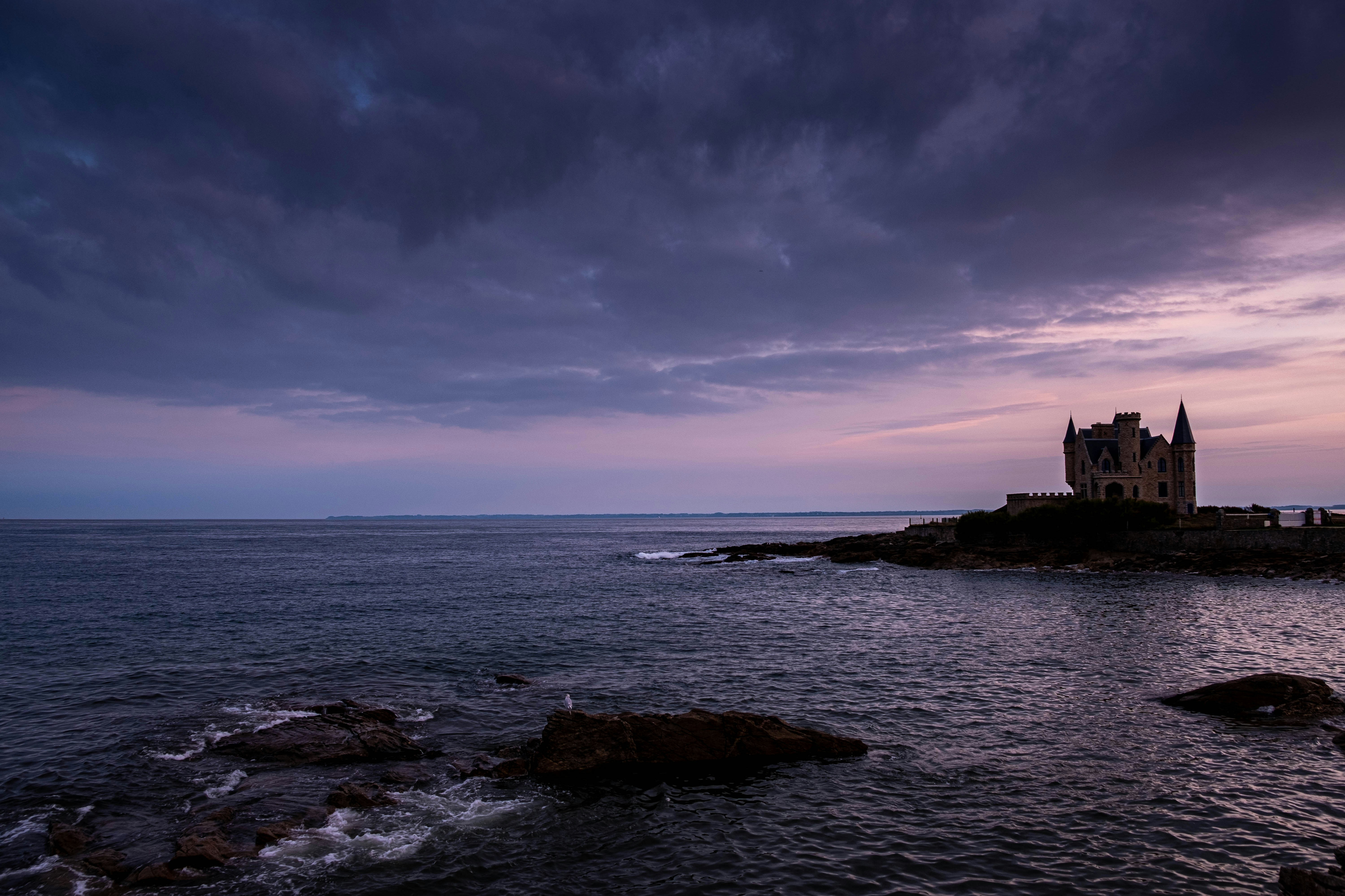 a castle sitting on top of a small island in the middle of the ocean