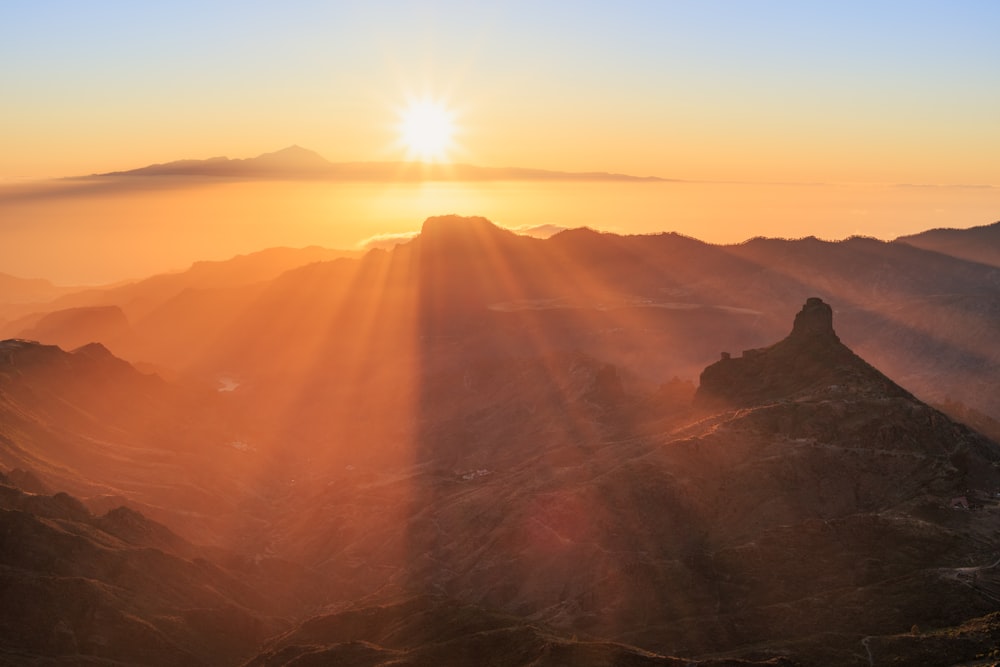 the sun is setting over a mountain range