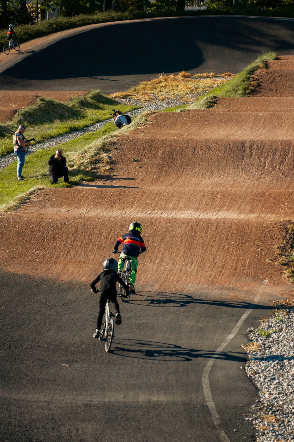 a group of people riding bikes down a dirt road