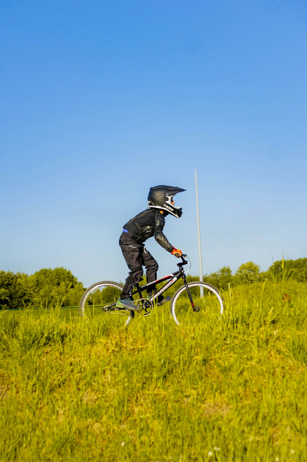 a man riding a bike on top of a lush green field