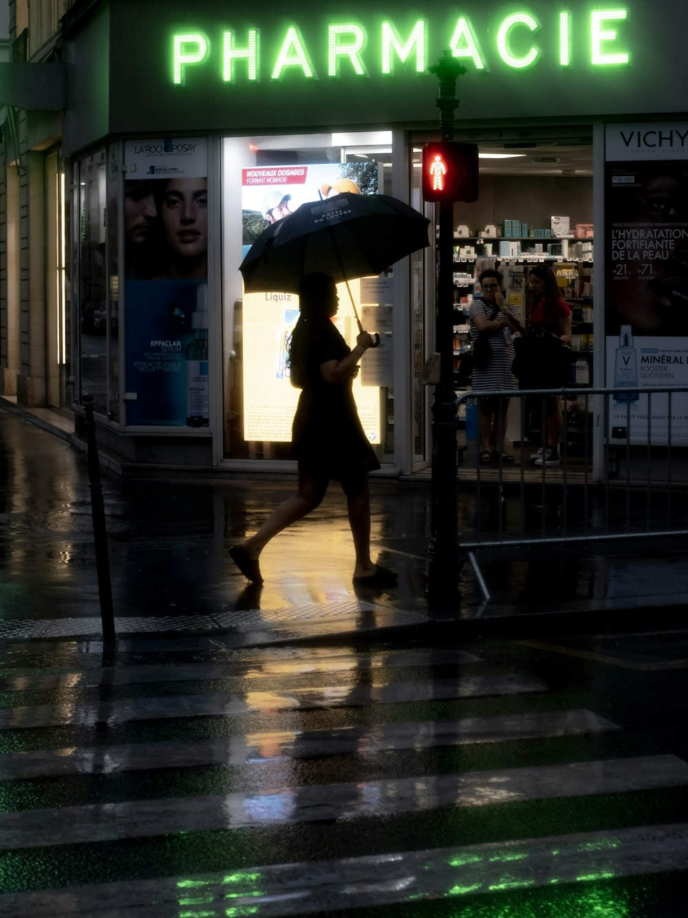 a woman walking down a street holding an umbrella