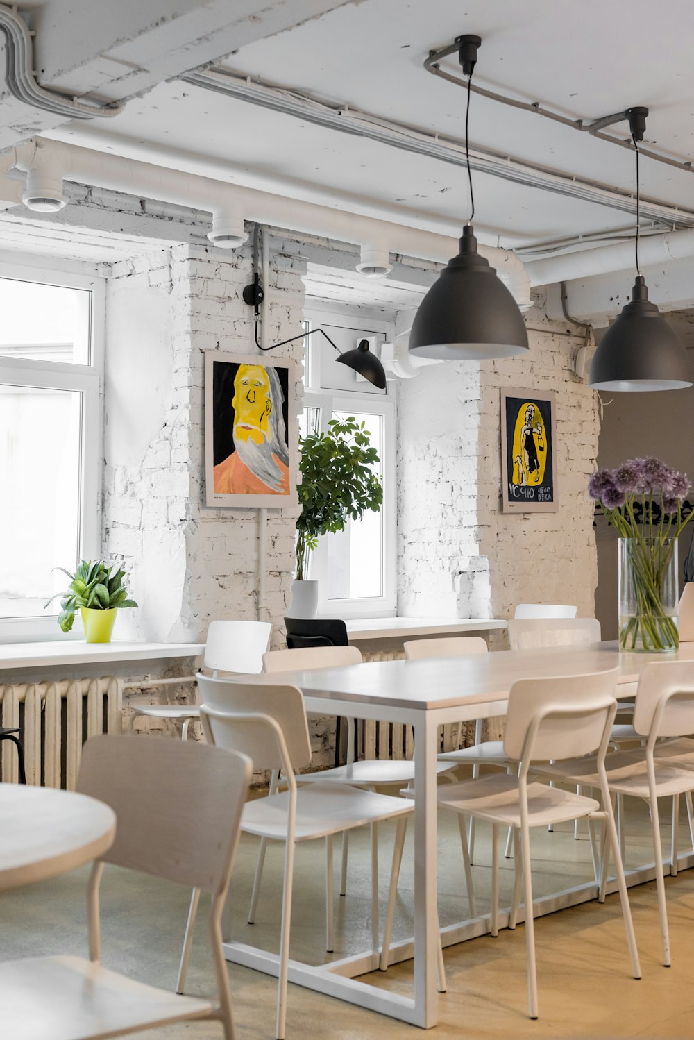 a room with a table, chairs, and pictures on the wall