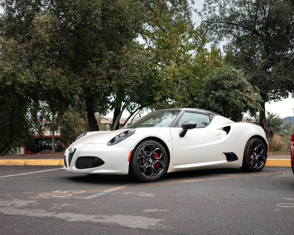 a white sports car parked in a parking lot