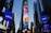 A cityscape with tall skyscrapers adorned with bright, colorful digital billboards. Various ads are displayed for well-known brands, including Yahoo, Dunkin' Donuts, and FOX. The scene is captured during the early evening, with a clear sky above.
